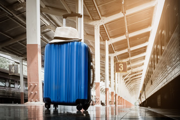 summer day,Blue luggage and hat white on floor at platform of ra