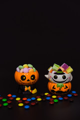 Halloween pumpkin doll head Jack lantern with candy on black background ,trick or treat