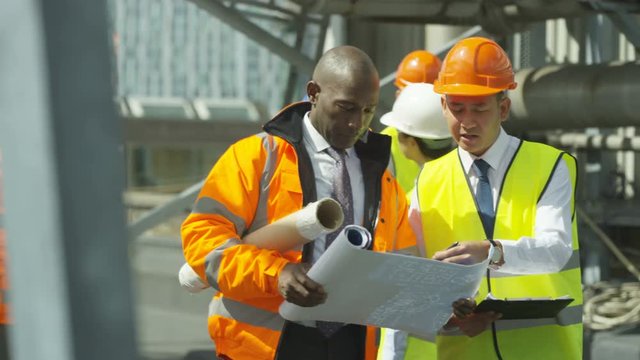  Multiracial team of engineers working together at construction site