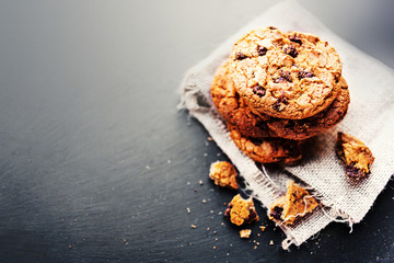 Chocolate chip cookies on dark  with place for text, freshly baked. Selective Focus with Copy space. Rustic styled image. Heap of tasty cookies.