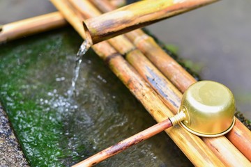 Obraz premium Isolated Golden Ladle at a Japanese Shrine