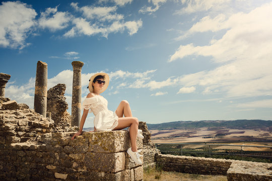 Girl in white dress on vacation. Girl on the ruins. Rest, travel, vacation. Tunisia, Dougga.