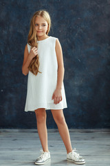 Beautiful girl with wavy hair posing in a dress