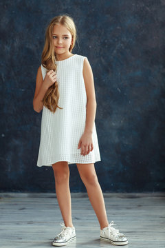 Beautiful girl with wavy hair posing in a dress