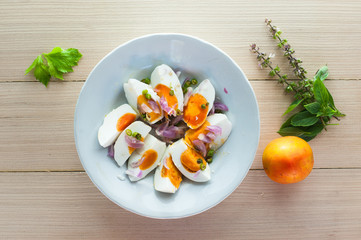 salted egg salad on white dish with tomato and basil