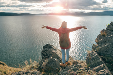 Woman traveler with open arms embrace the sky