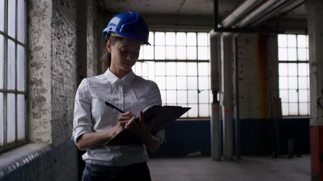  Female architect or engineer inspecting an empty building