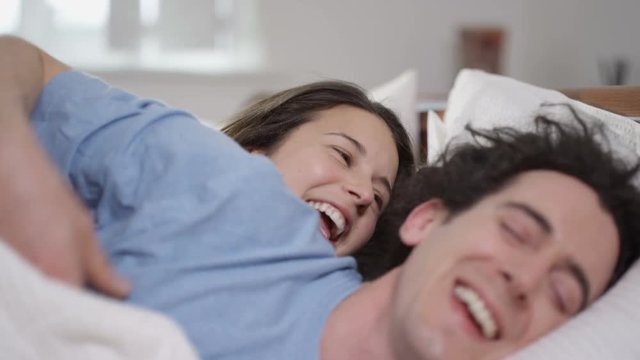  Happy couple enjoying early morning affections in the bedroom