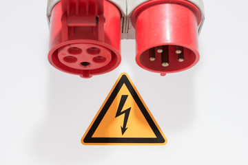 Kraftstrom Kupplung und Warnschild gefährliche elektrische Spannung