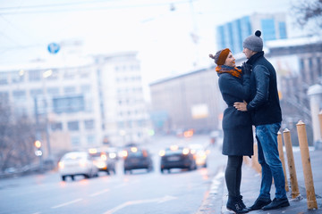 young man and woman hugging kissing outside