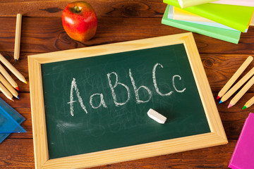 back to school - apple and books with pencils and blackboard