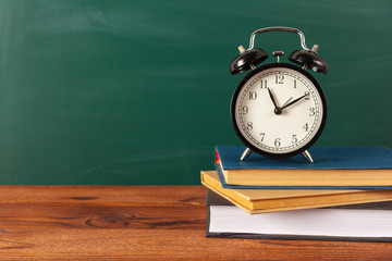 School supplies on a wooden table and blackboard