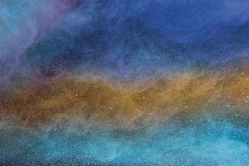 Abstract multicolored powder is spread full in area, horizontal view.