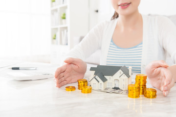 lady showing house model with gold coin stock
