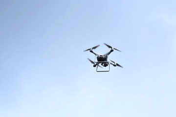 Drone hovering on blue sky