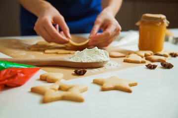 Cooking Christmas gingerbread cookies decorating for new year celebration. Female hands with gingerbread dough and cookie cutters