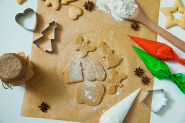 Cooking Christmas gingerbread cookies decorating for new year celebration. Dough and cookie cutters on baking paper