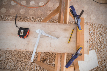 Carpenters equipment on a usty raw board in garage.