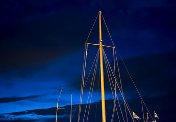 Sail masts against night blue sky.