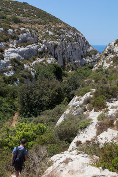 Exploring Wied Babu, at Wied iz-Zurrieq, green rocky valley, leading down to the azure turquoise water of the Blue Grotto, Zurrieq, Malta, May 2017