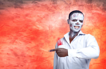 Man shows a finger in the direction. African man on fiery red background. Fashion male zombies, voodoo. Terrible things. Concept of advertising discounts on Black Friday. Hot sale. Skeleton office man