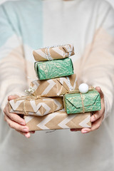Woman's hands hold gift boxes. Christmas or new year decorated gift box.