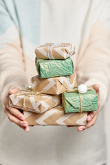 Woman's hands hold gift boxes. Christmas or new year decorated gift box.