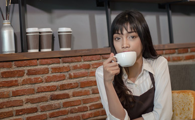 Waitress or barista in apron holding and drink coffee.small business owner,