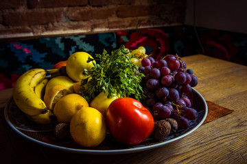 Delicious fruits in a plate on a wooden table