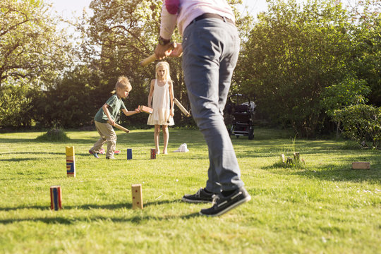 Children (4-5, 8-9) playing Kubb