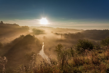 Beautiful dawn at foggy valley in autumn