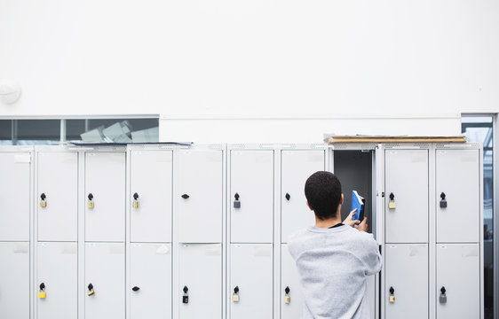 Student putting book into locker