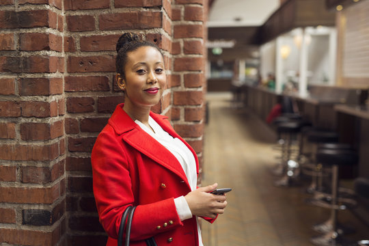 Portrait of woman in red coat in bar