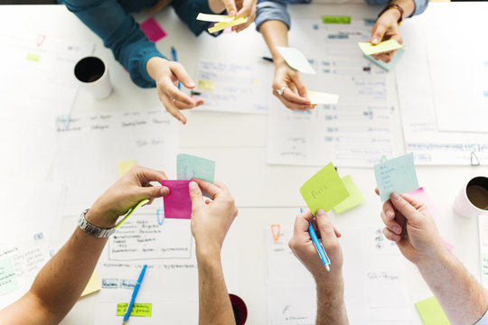 Colleagues using adhesive notes during business meeting