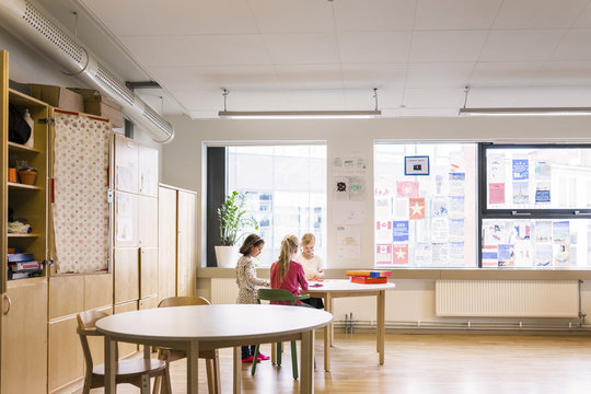 Three girls playing in classroom