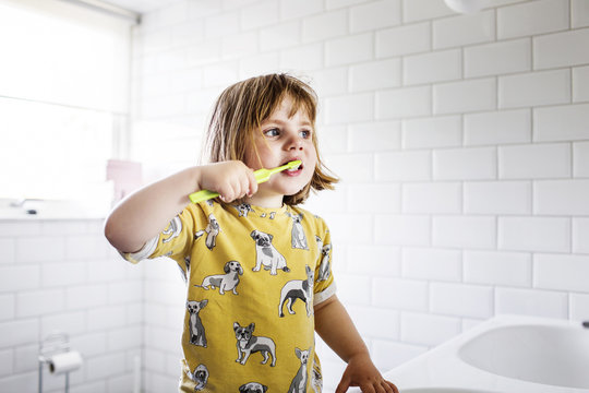 Small girl (2-3) brushing teeth
