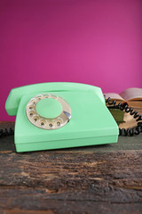 Green retro telephone on grey wooden table