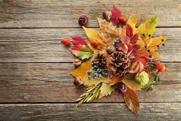 Autumn leafs with berries on grey wooden table