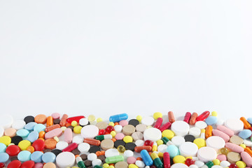 Different colorful pills on white background