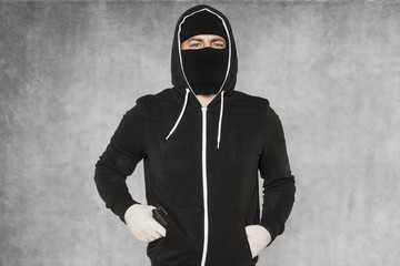 The burglar holds the gun in his pocket