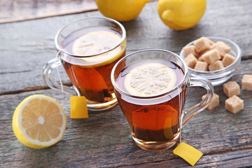 Cup of tea with teabag and lemon on wooden table
