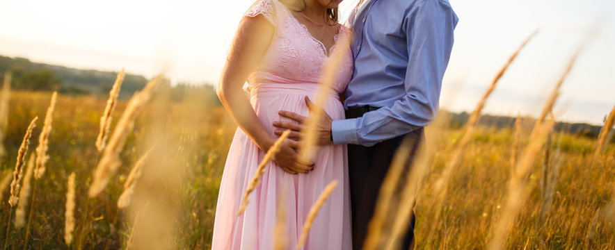 beautiful pregnant girl and her husband in the nature