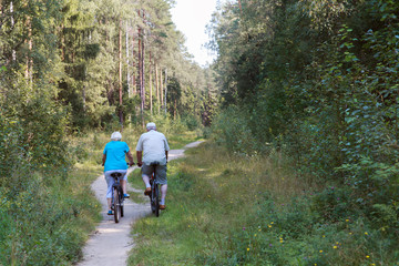 active senior couple riding bikes in nature