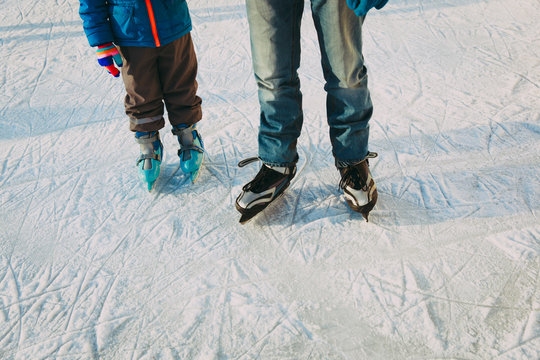 father with little son skating, family winter sport