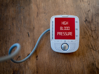 Medical device show high blood pressure on monitor. Digital measuring of health.  Text on red varning display.