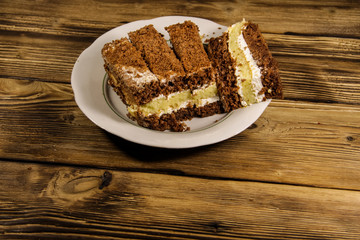 Sour cream cake on plate on wooden table