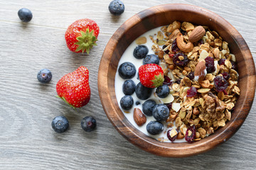 Homemade  granola with  fresh berry in wooden bowl