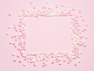 Fototapeta na wymiar Pink and white Marshmallows frame on pink background Top view, flat lay. free space for your text