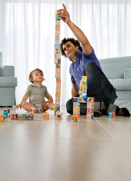 Baby watching father building cube tower