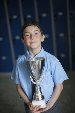School boy holding trophy